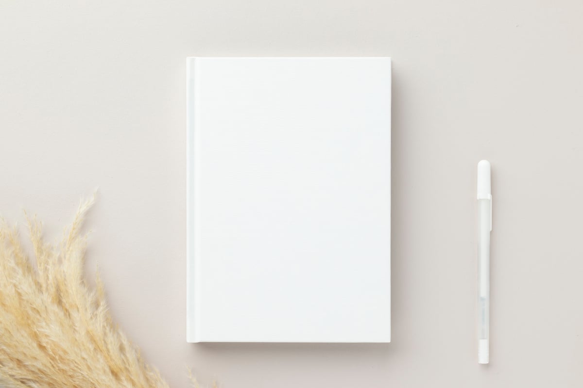 White book blank cover mockup on a beige background, flat la