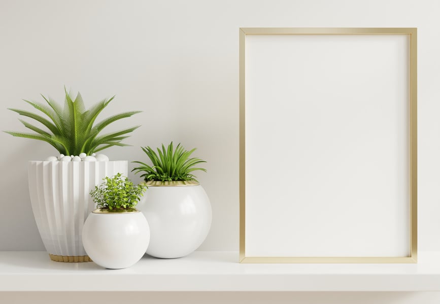 Picture Frame Mock Up Beside Ceramic Vases on a Shelf 